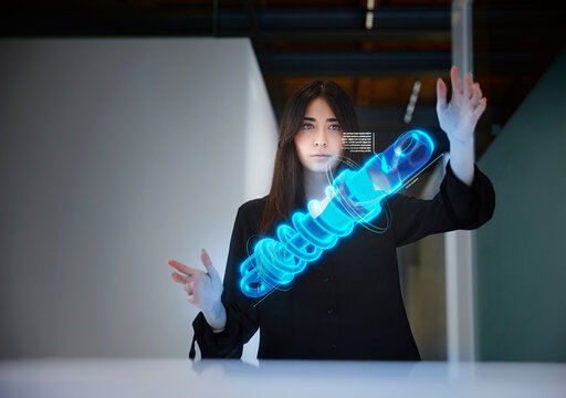 Female engineer analyzing shock absorber in mid-air at office