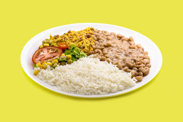 rice and beans dish, chopped tomato salad with corn and peas, on isolated yellow background, traditional brazilian meal