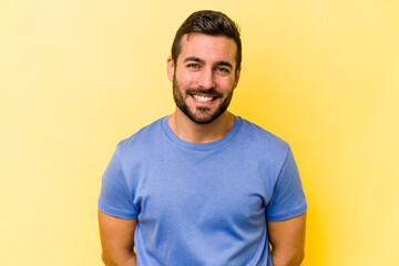 Young caucasian man isolated on yellow background happy, smiling and cheerful.