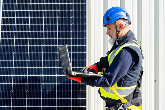 Technician working on laptop at solar power station