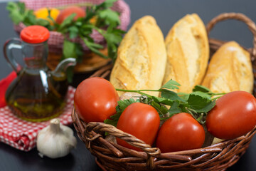 Cesta con pan, tomate y perejil, para preparar un desayuno típico de la zona del Mediterráneo