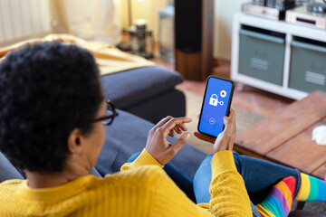 Woman using app on smart phone in living room