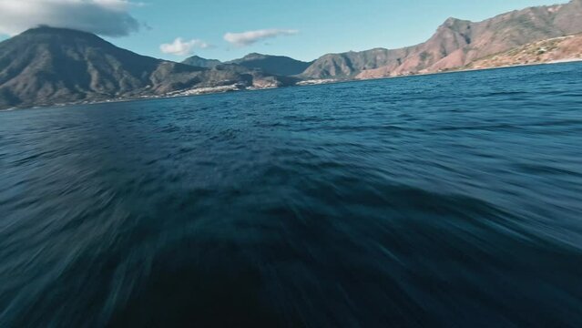 FPV flying over lake Atilan with majestic mountain range in background view