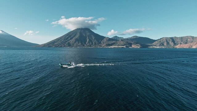 Volcano mountain and sailing boat in Atilan Lake, aerial fpv view