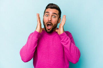 Young caucasian man isolated on blue background surprised and shocked.
