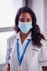 Portrait Of Female Mature Nurse In Uniform Wearing Face Mask In Hospital