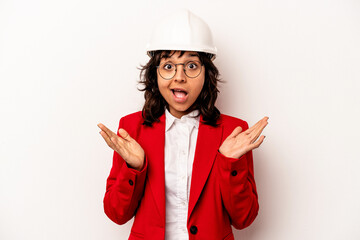 Young architect hispanic woman with helmet isolated on white background surprised and shocked.