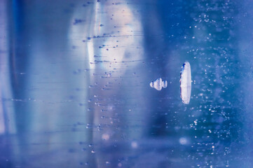 Fototapeta premium Air bubbles rising from the bottom froze in transparent blue ice. Ice pattern and texture.