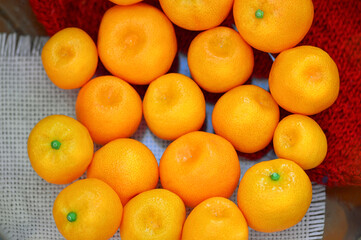 Ripe tangerines lie on the table on a red wool background. The ripening season of tropical citrus fruits. Close-up. Top view