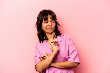 Young hispanic woman isolated on pink background confused, feels doubtful and unsure.