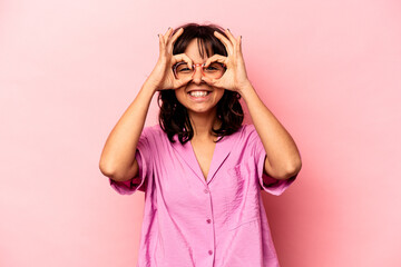 Young hispanic woman isolated on pink background excited keeping ok gesture on eye.