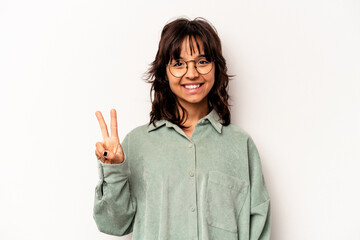 Young hispanic woman isolated on white background showing victory sign and smiling broadly.