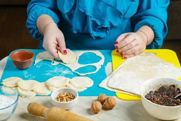 Foto op Canvas A Jewish woman makes dough blanks Gomentashi cookies, traditional for the Jewish holiday of Purim. © finist_4