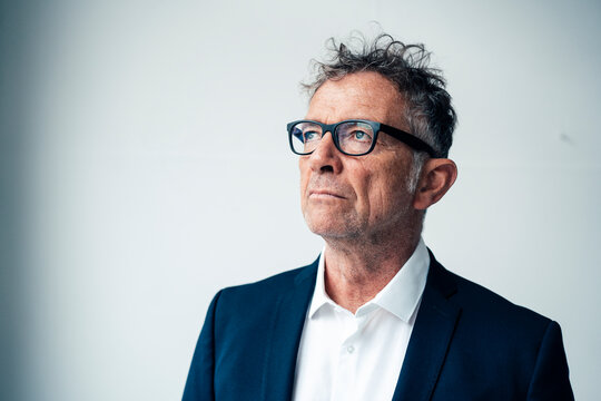 Thoughtful Businessman In Suit Against White Background