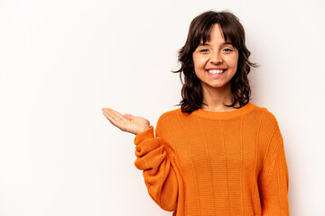 Young hispanic woman isolated on white background showing a copy space on a palm and holding...