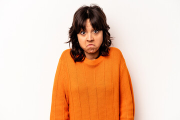 Young hispanic woman isolated on white background shrugs shoulders and open eyes confused.