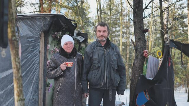 A Homeless Man And Woman Giving An Interview In The Winter In The Woods.