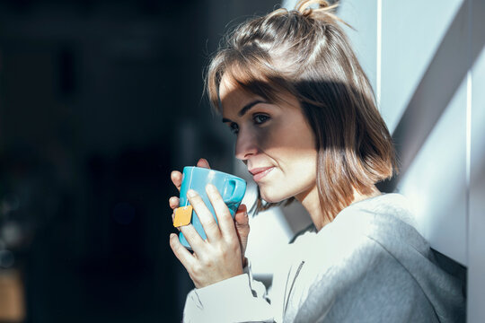 Woman Having Tea By Wall