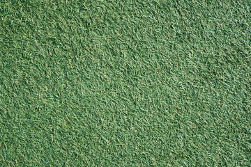 Green grass texture. Artificial grass background. Lawn in backyard. Garden backdrop. Vibrant color closeup macro pattern.