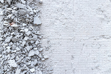 A pile of broken floor tiles on the floor of a construction site.  background a pile of broken concrete. top view. flat lay