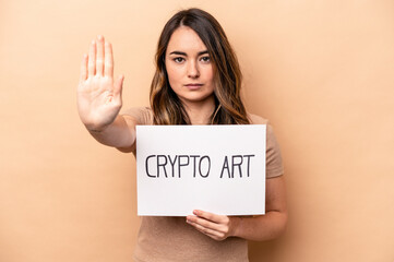 Fototapeta na wymiar Young caucasian woman holding a crypto art placard isolated on beige background standing with outstretched hand showing stop sign, preventing you.