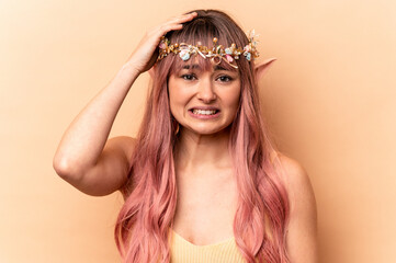 Young elf woman with pink hair isolated on beige background being shocked, she has remembered important meeting.