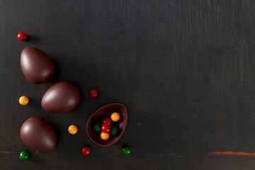 delicious chocolate easter eggs on old black wood background. flat lay. top view. happy easter day concept. 3D illustration
