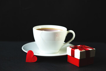 White cup of tea on a black background.