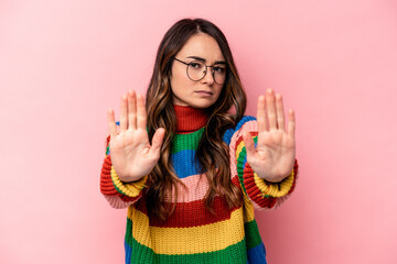 Young caucasian woman isolated on pink background standing with outstretched hand showing stop...