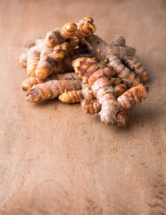 turmeric roots, traditional southeast asian spice on a wooden table top, also known for medicinal purposes, taken in shallow depth of field