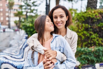 Naklejka premium Woman and girl mother and daughter hugging each other at park