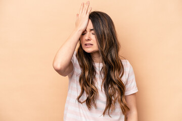 Young caucasian woman isolated on beige background forgetting something, slapping forehead with palm and closing eyes.