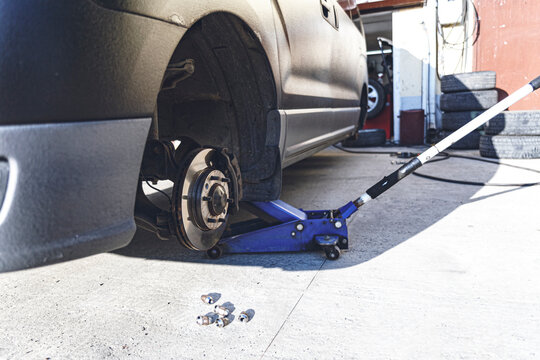 Car with tires removed at auto repair workshop