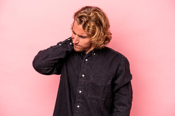 Young caucasian man isolated on pink background having a neck pain due to stress, massaging and touching it with hand.