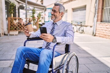 Fototapeta na wymiar Middle age hispanic man sitting on wheelchair using smartphone at street