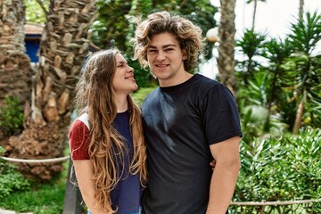 Young caucasian couple smiling happy and hugging at the park.