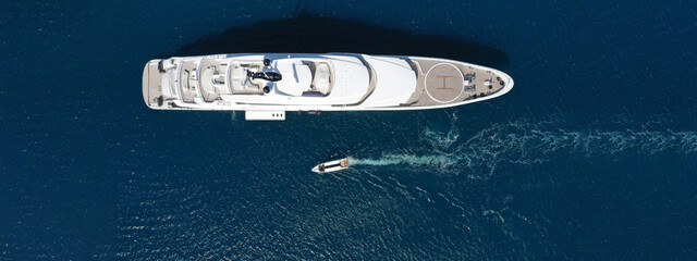 Aerial drone ultra wide panoramic photo of luxury yacht with wooden deck anchored in Mediterranean open ocean deep blue bay