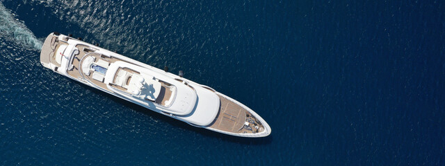 Aerial drone ultra wide top down photo of large yacht with wooden deck anchored in Aegean island...