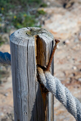 Ein Seil, Absperrseil an einem hölzernen Pfosten befestigt, als Wegeinzäumung.