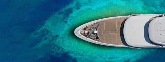 Aerial drone ultra wide top down photo of luxury exotic yacht nose with wooden deck anchored in...