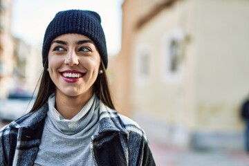 Young hispanic woman smiling happy standing at the city.