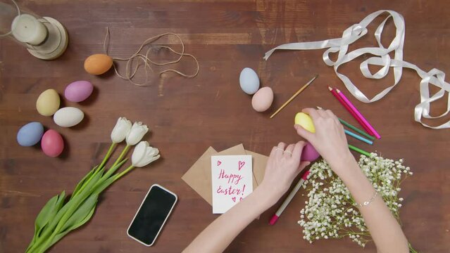Top view of a table with items to create a composition for Easter. Women's hands arrange objects on the table. Church holiday-Easter