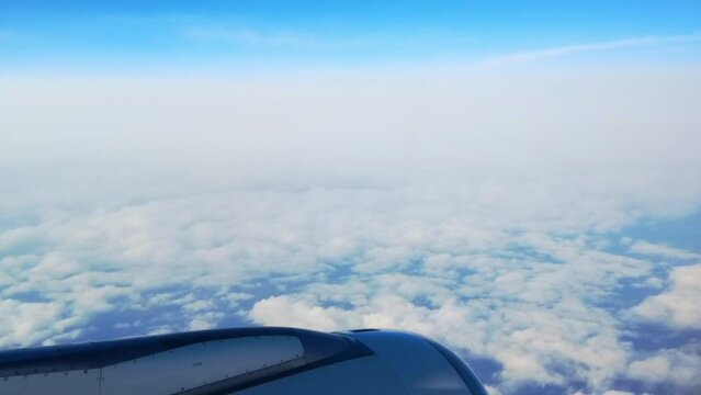 Beautiful view from plane seat. Cloudy weather with little blue sky