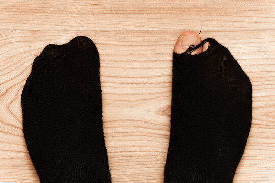 Closeup Shot Of Male Feet In Hoaly Socks With Sticking Out Toe.