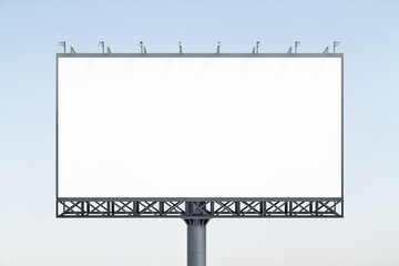 Blank white horizontal billboard on blue sky background at sunset, front view. Mock up, advertising concept