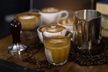 cup of coffee latte art in barista hand.