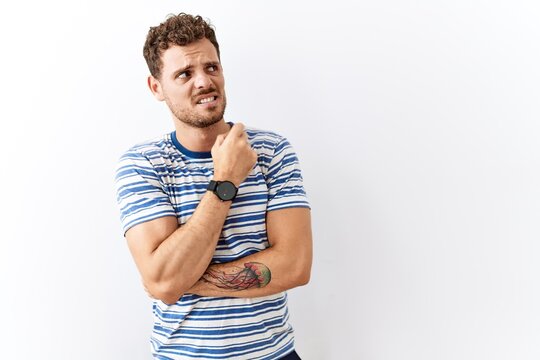 Handsome young man standing over isolated background thinking worried about a question, concerned and nervous with hand on chin