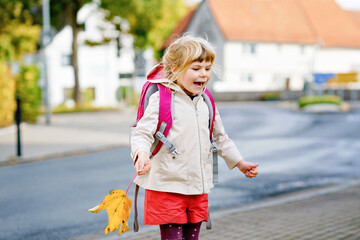 Cute little preschool girl on her first day going to playschool. Healthy happy child walking to...
