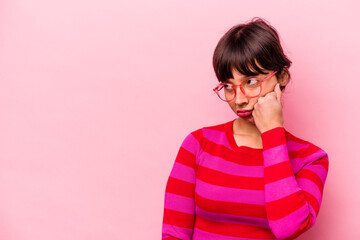 Young hispanic woman isolated on pink background who feels sad and pensive, looking at copy space.