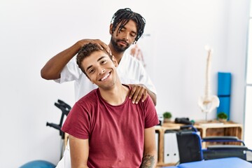 Two men physiptherapist and patient having rehab session stretching neck at clinic